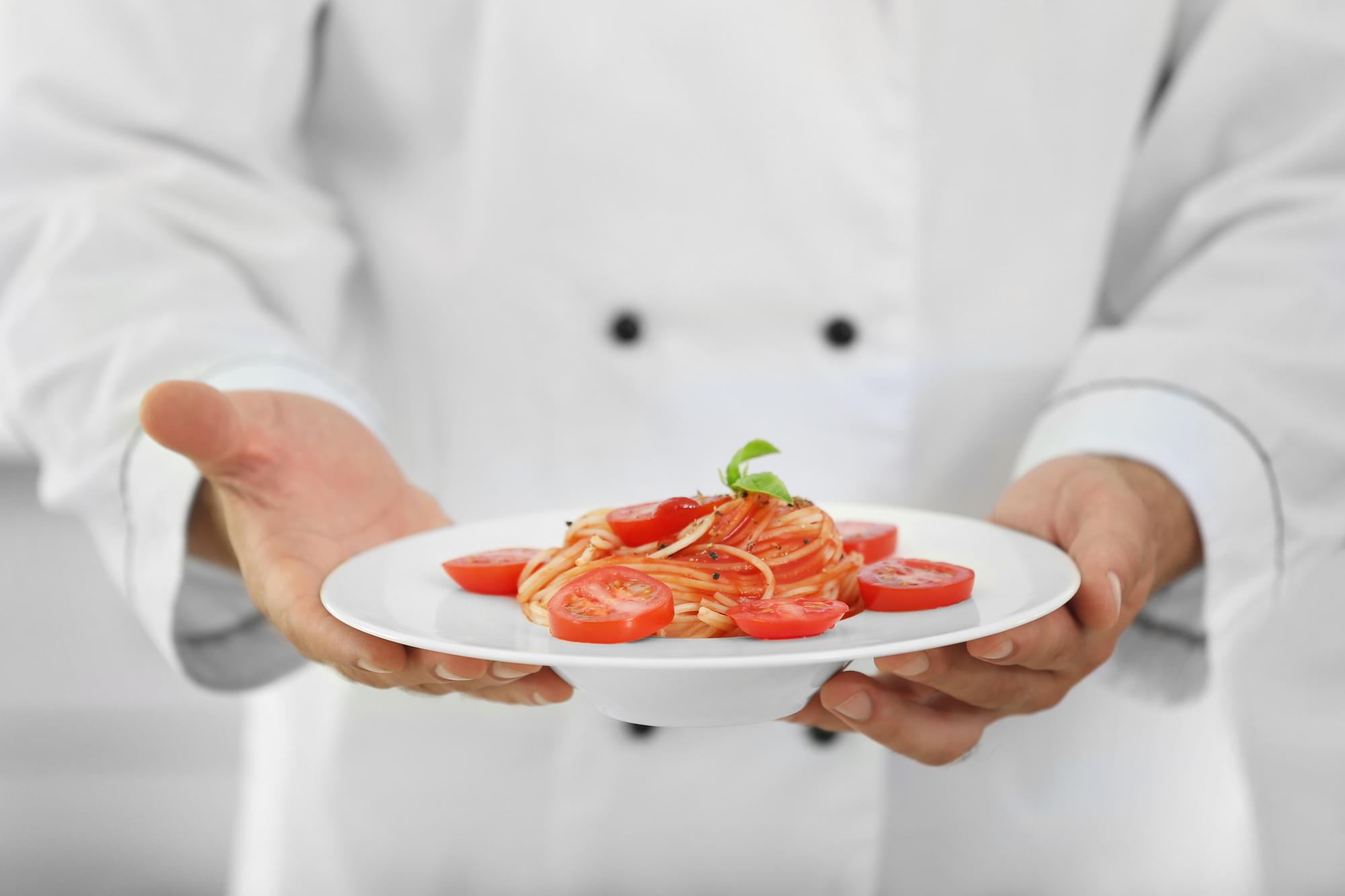 Chef plating final dish in kitchen